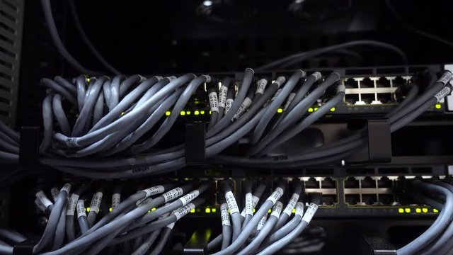 Provider concept. Close up view of internet equipment and cables in the dark server room.