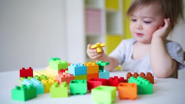 baby plays in the constructor. small child builds a castle out of blocks. concept of development of fine motor skills. game at home