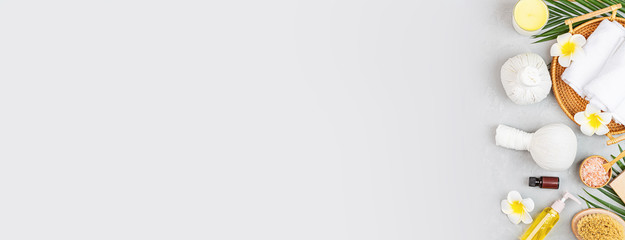 Spa massage Aromatherapy body care background. Spa herbal balls, cosmetics, towel and tropical leaves on gray concrete table. Top view, flat lay, overhead, copy space. Beauty and health care concept