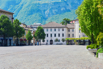 Naklejka premium Old historyc market square in the italian city Trento with nobody on it, empty of people street. With Alpine mountain wiew on the background