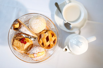 Colazione tipica all'italiana con dolci latte e caffe fotografata dall'alto su sfondo bianco