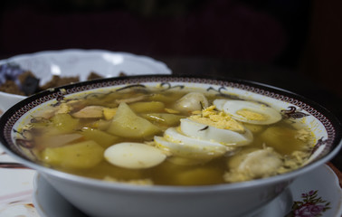 Chicken soup with noodles, carrots, eggs and cheese croutons