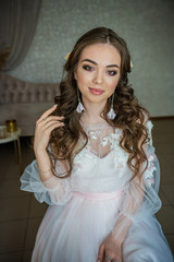 Beautiful festive make-up on a girl in a white dress.