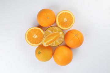 Fresh yellow orange juice in glass with whole sliced orange fruit and ice cube on white background