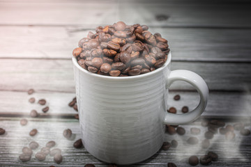 Coffee cup and beans coffee on a white background. Morning coffee smoke on a wooden background