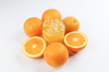 Fresh yellow orange juice in glass with whole sliced orange fruit and ice cube on white background