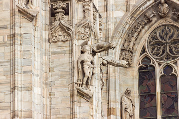 Decorative stone statues on the outer wall of the Cathedral of Milan - Duomo di Milano in Milan, Italy