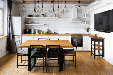 Modern scandinavian an eat-in kitchen interior design with big wooden table and chairs against...