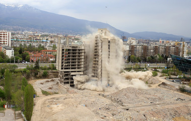 Controlled explosion with blasts of a unfinished and abandoned empty high building, printing press...