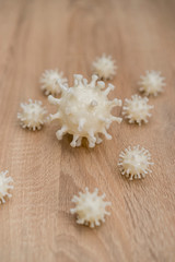 covid19, 3d printed representation of the virus on a wooden surface. home security and protection against viruses