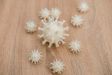 Obraz na płótnie Canvas covid19, 3d printed representation of the virus on a wooden surface. home security and protection against viruses