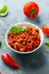 Sun dried tomato pesto in white bowl.