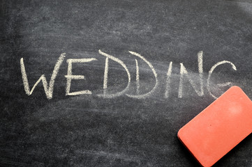 Fototapeta premium erasing wedding, hand written word on blackboard being erased concept