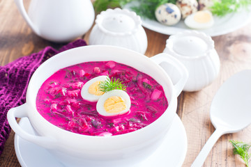 Traditional cold summer beetroot soup with vegetables in a white bowl, selective focus