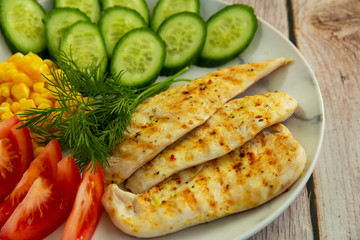 Grilled chicken with cucumbers, tomatoes, corn and herbs