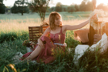 A beautiful young girl in nature in a rustic style in green grass, boho and rustic style, ...