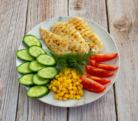 Grilled chicken with cucumbers, tomatoes, corn and herbs