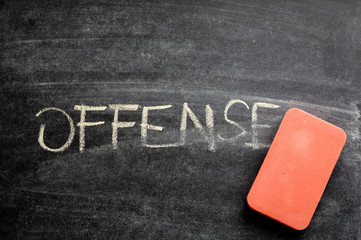 erasing offense, hand written word on blackboard being erased concept