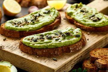 Healthy Homemade Avocado creamy Toast with nuts mix on wooden board