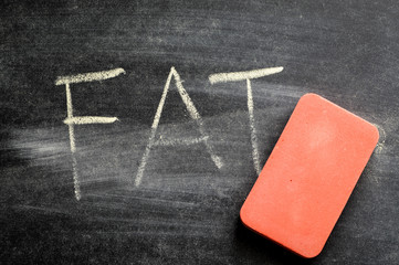 erasing fat, hand written word on blackboard being erased concept