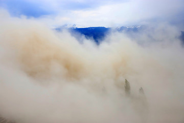 Heavy air pollution. Extremely polluted air with mountain as background. Cloud of dust.
