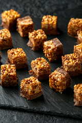 Crispy rice bar, snack with caramel and chocolate on rustic background