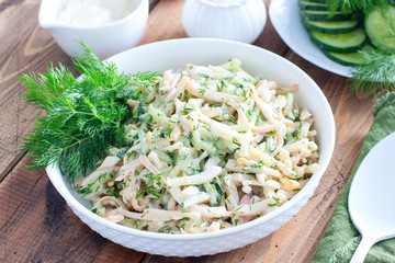 Salad with squid, eggs and fresh cucumbers, selective focus