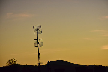 silhouettes of antennas at orange sunset