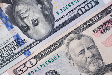 100 dollar bill and 50 dollar bill are side by side diagonal. 150 dollars money background.