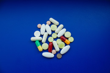 Macro shot of colorful tablets and capsules on dark blue background