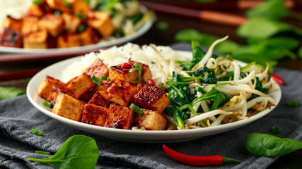 Fried Asian tofu in sweet chilli glaze served with rice, steamed spinach and beansprouts. Vegetable healthy food