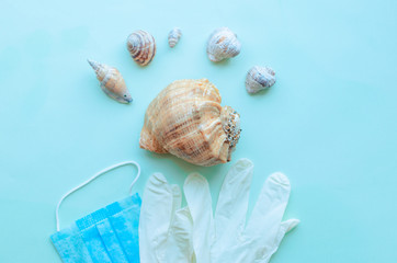 Summer vacation beach rest and medical protective mask, gloves, antiseptic on mint blue background. Coronavirus covid-19 travel. Flat lay. Copy space. pandemic quarantine self isolation, 2019-nCoV