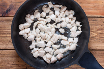 Step-by-step cooking of stewed cabbage with chicken breast, step1 - frying chopped chicken breasts, selective focus