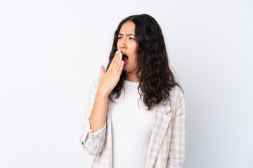 Mixed race woman over isolated white background yawning and covering wide open mouth with hand