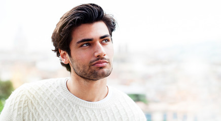 Beautiful model Italian man. Charming young man outdoors alone, looking to one side with positive...