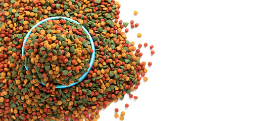 Above or Top view. Colourful Dried dog food in blue bowl on white background. Grain pet food banner background with copy space for text design.