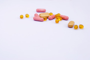 Few multi-colored pills on a light purple background. Omega-3, dietary supplements and pink...
