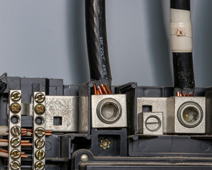 Wiring in electrical circuit breaker box panes with bus bar and copper wires. Concept of home maintenance, repair and remodeling