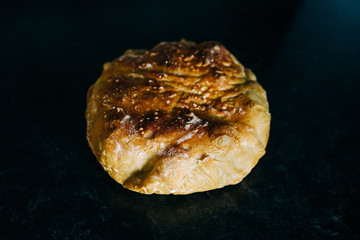 round loaf of sourdough white homemade break on a dark surface