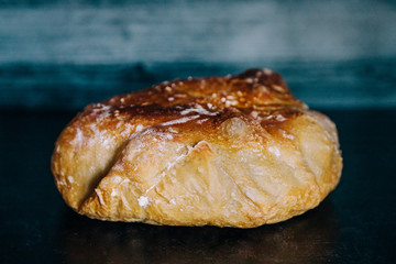 round loaf of sourdough white homemade break on a dark surface