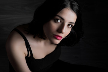 Naklejka premium Young woman looking at camera isolated on black background. Beautiful woman portrait.