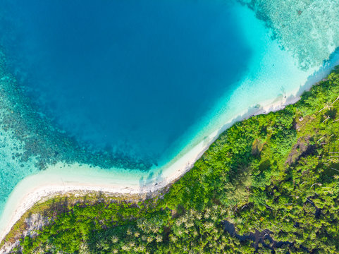 Aerial top down view tropical paradise pristine beach rainforest blue lagoon bay coral reef caribbean sea turquoise water at Banyak Islands Indonesia Sumatra remote travel adventure away from it all