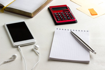 Notebook and pen, selfphone and headphones, calculator. Work from home.