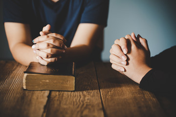 Couple teen boy and girl are pray together on wooden table