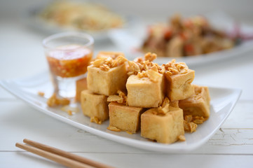 Deep fried tofu is cut into square balls on plate