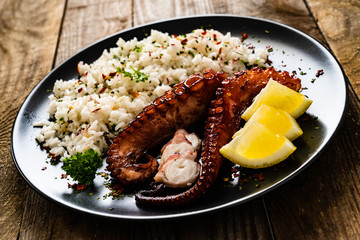Fried octopus with white rice on wooden table
