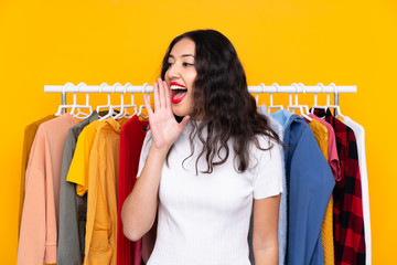 Mixed race woman in a clothing store shouting with mouth wide open