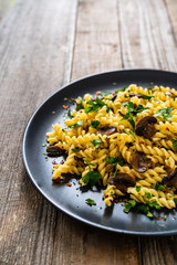 Fusilli with chmpignons on wooden table
