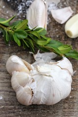 Garlic head with herbs on a wooden background.Macro.