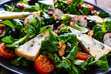 Fresh salad - blue cheese and vegetables on wooden table